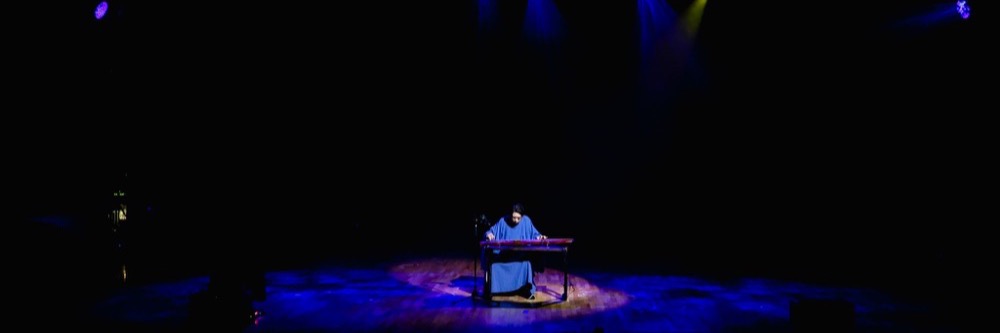 Guqin performer on stage during The Discourse of an Instrument, and a Thousand Machines