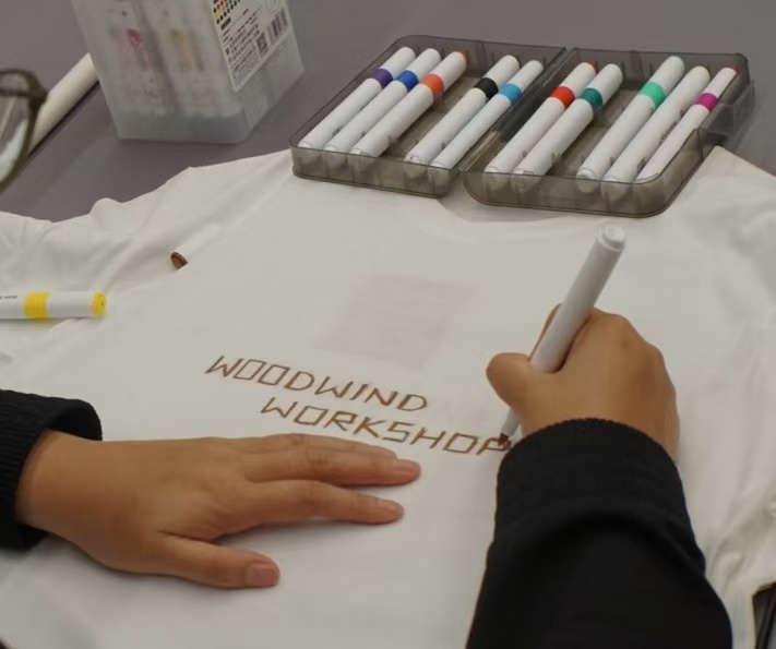 Wood Wind Workshop participant drawing on a workshop T-shirt